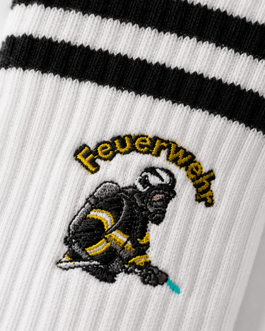 Feuerwehr Bundle Socken von HeroSoxx – Nahaufnahme einer Socke mit "Feuerwehr"-Schriftzug über einem Feuerwehrmann-Symbol in voller Schutzausrüstung